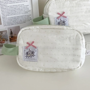 Detail of mint green polka dot elephant makeup bags with quilted texture and bow