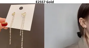 Detail of gold heart long tassel earrings with white beads on model and display card