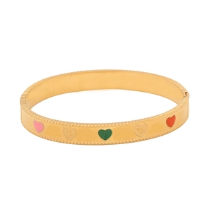 Detailed view of gold vintage bangle featuring colorful enamel hearts and textured patterns
