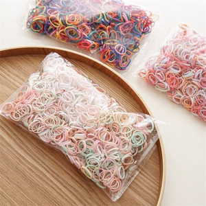 Close-up of colorful high-elasticity hair ties in a wooden tray and transparent bags