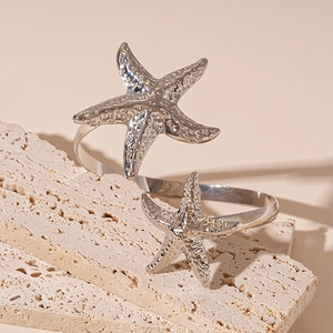 Macro detail of silver starfish arm cuffs featuring realistic textured metal finish