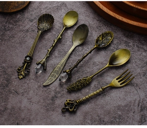 Macro shot of 6-piece vintage bronze coffee spoons and dessert fork on slate