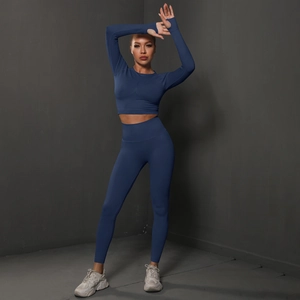 Detail of seamless dark blue yoga set with long sleeve thumb hole crop top and leggings