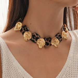 Close-up of leopard print resin squares and gold shell accents on a stylish necklace