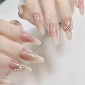 Long almond nude gradient press-on nails with luxury rhinestones and metal chain detail