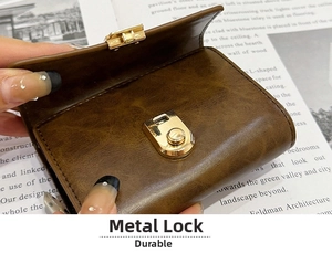 Close-up of golden hardware lock on brown lychee texture leather wallet and card holder