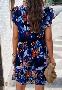 Détail d'une élégante robe en mousseline fleurie bleu marine avec des manches à volants