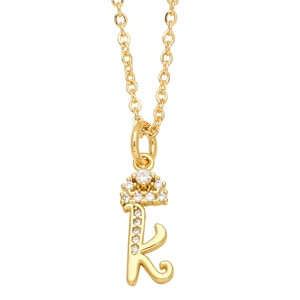 Close-up of golden letter K pendant with crown detail and sparkling small rhinestones