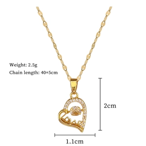 Detail showing gold heart pendant dimensions 1.1x2cm with love engraving and cubic zirconia