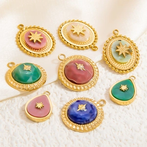 Detail of star-engraved gold charms with colorful natural stones on white silk texture