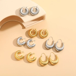 Detailed view of six pairs of gold and silver hammered and twisted hoop earrings