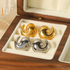 Water drop curved earrings in 18K gold and silver finishes on a wooden jewelry box