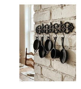Détail de décoration murale de cuisine rétro en fonte avec crochet fleur de lys et mini pots