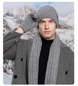 Close-up of grey knit hat, scarf and gloves set with thick cable texture for winter