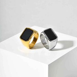 Detailed view of gold and silver square black stone signet rings on white blocks