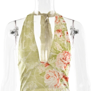 Détail de la robe licou avec décolleté en V profond et motifs floraux roses sur tissu vert clair