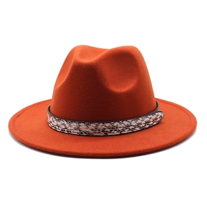 Detail of caramel fedora hat with a wide brim featuring a faux snakeskin band and gold rivet
