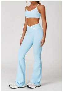 Detail van een high-waist yoga broek met witte contrasterende bies en uitlopende pijpen