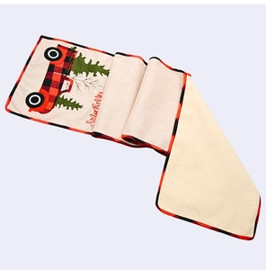 Detail of Christmas table runner with red plaid truck and Snowman text on linen fabric