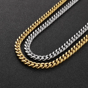Mens Cuban link chain necklace in gold and silver finish on textured background