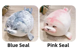 Close-up of soft blue and pink plush seals with cute embroidered faces on beige carpet