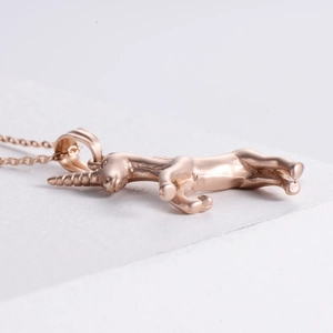 Macro detail of sandblasted rose gold unicorn pendant showing embossed relief details