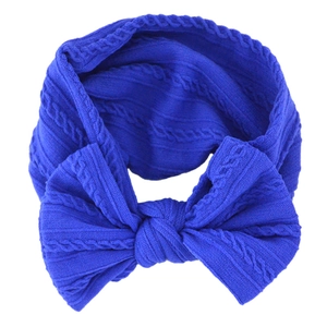 Close-up of blue soft knitted baby headband with a decorative jacquard bow detail