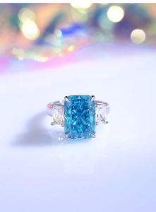 Macro shot of an 8 carat emerald cut blue gemstone ring with side baguette diamonds