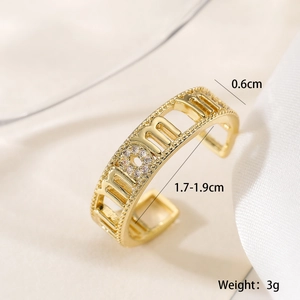 Macro shot of gold plated MOM letter ring with sparkling zircons and hollow design details