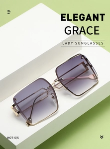 Detail of square gold metal sunglasses with purple gradient lenses on a white display