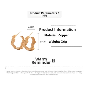Detail view of hammered texture on round C-shaped earrings with 2.5cm diameter