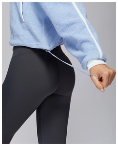 Detail of light blue fleece jacket with drawstring hem and gray yoga pants set