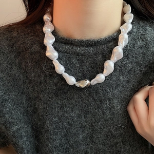 Gros plan d'un collier de perles baroques irrégulières avec fermoir argenté sur un mannequin