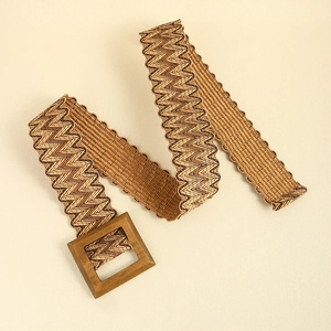 Detail of a brown straw woven belt featuring a square wooden buckle and chevron texture