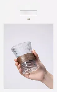 Close-up of vertical ribbed glass cup featuring a handcrafted wooden heat insulation sleeve