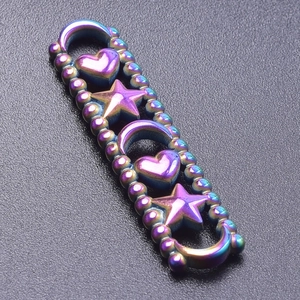 Macro shot of rainbow-colored heart, star, and moon charms on a metal jewelry connector