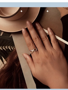 Close-up of infinity heart two-tone silver ring worn on hand in a luxury lifestyle setting