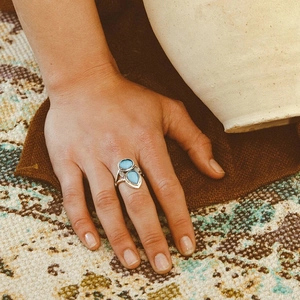 Dettaglio anello bohémien in argento con pietre azzurre indossato sulla mano