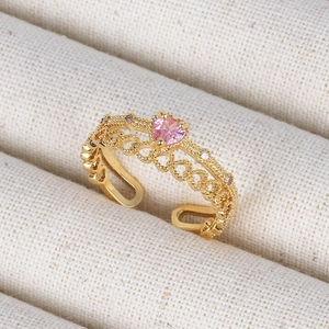 Macro view of 18K gold hollow heart ring featuring a pink heart gem and zircon details