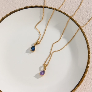Détail de colliers plaqués or 18 carats avec pendentifs en zircon bleu et violet
