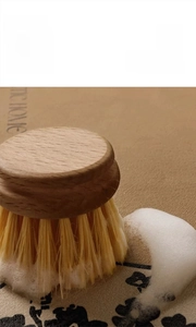 Macro shot showing cleaning foam on a floral absorbent mat with a wooden scrub brush