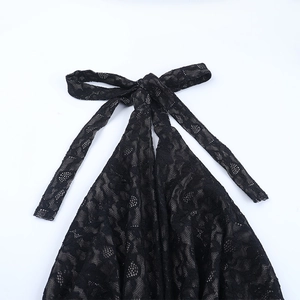Detailed close-up of a black lace jumpsuit featuring a stylish halter neck bow tie design