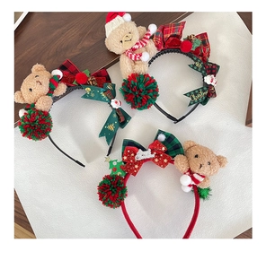 Flat lay of plush Christmas headbands with teddy bear and red green ribbon bow details