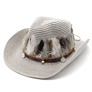 Detail of wide brim straw cowboy hat with ethnic beads, feathers and metal charms