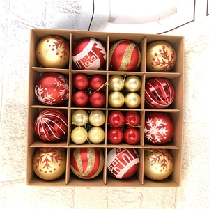 Close-up of red and gold Christmas ball ornaments with snowflake patterns in a gift box
