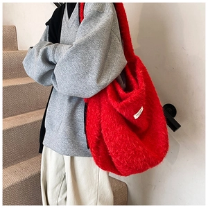 Detail of red faux fur shoulder bag showing plush texture and white decorative label