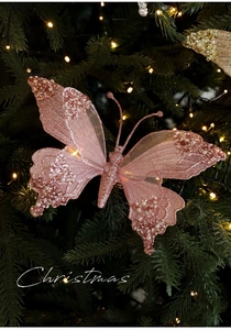 Ornamento a farfalla rosa glitterata con paillettes su rami di albero di Natale