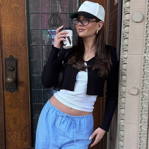 Nahaufnahme eines modischen schwarzen Crop-Cardigans mit weißen Knöpfen am Modell