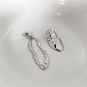 Close-up of asymmetrical 925 silver drop earrings with fluid lava texture on white background