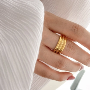 Close-up of golden multi-layered stackable ring with polished finish on a finger